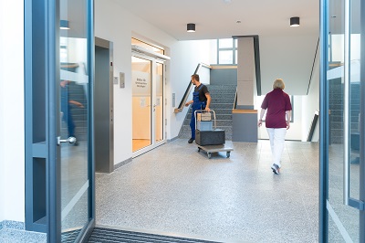 Eingangsbereich ins Gerontopsychiatrische Zentrum (GPZ/Haus 15) mit zwei Mitarbeitern